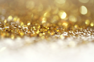 Gold (bronze) glitter shine dots confetti. Abstract light blink sparkle defocus backgound.