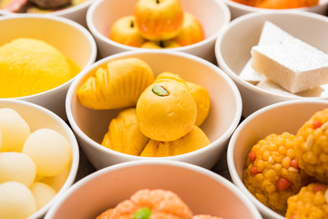 Fototapeta na wymiar Rangoli of Assorted Indian sweets/mithai in bowl for Diwali or any other festivals, selective focus