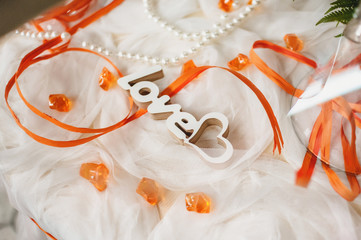 carved wooden word love is in tulle with orange ribbons.