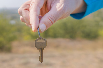 Keys in hand on blur landscape background