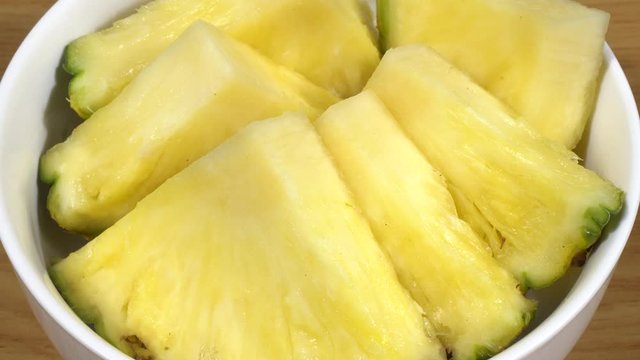 Pi&ntilde;a cortada en trozos en un bol de cer&aacute;mica