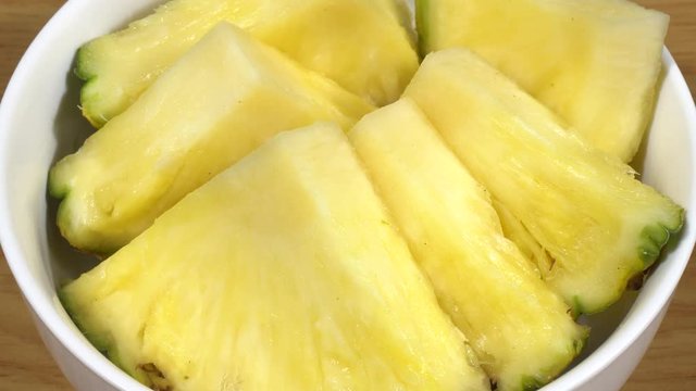 Pi&ntilde;a cortada en trozos en un bol de cer&aacute;mica