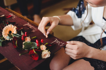 Friend of the bride writes a word..Preparations for the wedding..boutonnieres, lying on a brown table