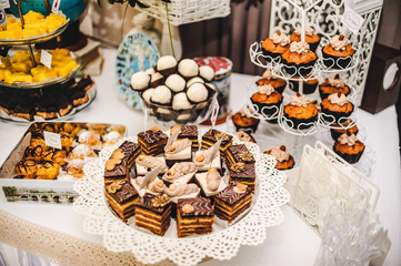 Colorful table with sweets and goodies for the wedding.party reception, decorated dessert table.Delicious sweets on candy buffet.Dessert table for a party. cakes, cupcakes, sweetness..