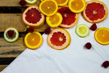 close up of fresh sliced citrus fruits against a rustic background in a flat layout