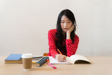 Close-up of female students taking notes on the notebook.