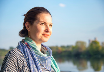 A large Portrait of a woman in her forties on the background of nature.