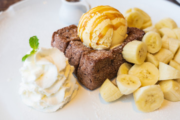 Close-up on, Honey Toast, bread buttered toast, banana, ice cream and whipped cream dessert on a white dish