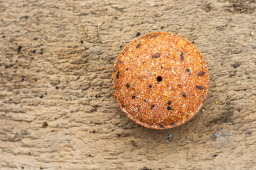 Flax seeds pressed into a round briquette. It is used as feed for animals, birds and fish. One of the feed ingredients. Copy space