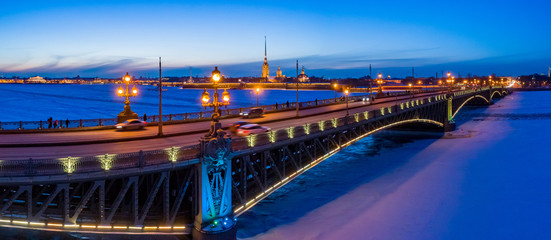 Russia. Panorama of Petersburg in the winter evening. Rivers Of St. Petersburg. Bridges Of St. Petersburg. The bridge across the river. Trinity bridge with burning lights. Winter trip to Russia