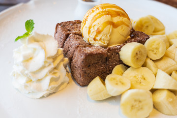 Close-up on, Honey Toast, bread buttered toast, banana, ice cream and whipped cream dessert on a white dish
