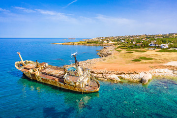 Cyprus. Pathos. White stone. Shipwreck. The ship ran aground top view. The ship crashed on the coastal rocks. Rusty ship at the shore of the Mediterranean sea. Tourist attractions of Cyprus.