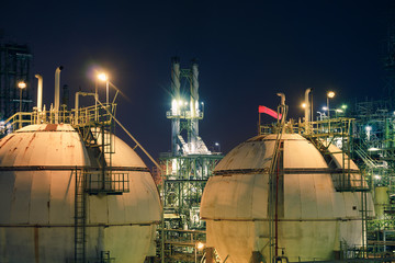 Gas storage sphere tank in gas and oil refinery plant at night, Close up of equipment in petrochemical plant, Glitter lighting of industrial plant