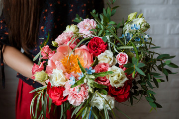 Floristic concept, business concept, gift, surprise, peonies, roses, carnations.  A large multi-colored bouquet stands on a chair. Peony, roses, carnations, eucalyptus, greens, garden flowers