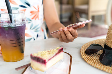 Close up of women's hands holding mobile phone in cafe.