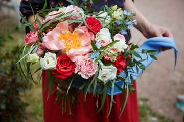 Florist girl collects a large beautiful bouquet. Floristic concept, business concept, gift, surprise, peonies, roses, carnations