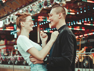Young couple in love having fun together at amusement park Holidays, love and friendship concept
