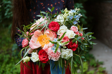 Obraz na płótnie Canvas Florist girl collects a large beautiful bouquet. Floristic concept, business concept, gift, surprise, peonies, roses, carnations