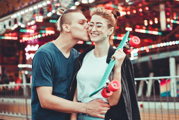 Obraz na płótnie Canvas Young couple in love having fun together at amusement park Holidays, love and friendship concept