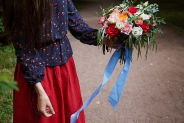 Fototapeta na wymiar Florist girl collects a large beautiful bouquet. Floristic concept, business concept, gift, surprise, peonies, roses, carnations