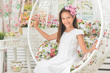 Fototapeta na wymiar Emotional little girl in a white dress posing