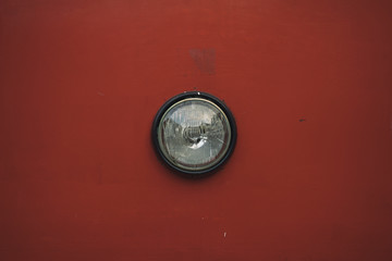 vintage artistic picture of old tram headlamp on tram frame red shabby surface background, copy space 