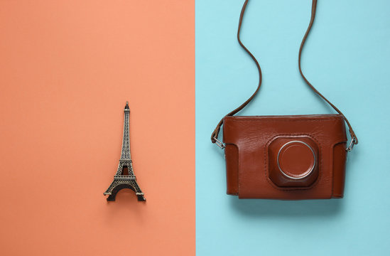 Retro picture with retro camera and eiffel tower figure on colored paper background.
