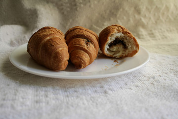 .croissants in a plate on a light background in a warm room in the morning