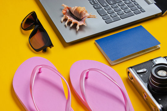 Summer leisure. Summertime relax.Laptop and beach accessories on yellow background. Studio short. Beach object.