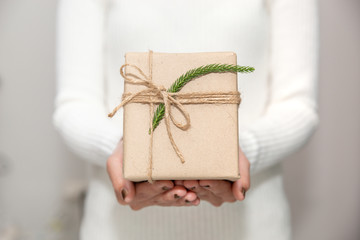 Woman hands with white sweater holding a diy gift box for special event with copy space.