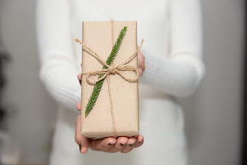 Woman hands with white sweater holding a diy gift box for special event with copy space.
