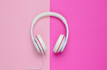 Classic white wired headphones on colored paper background. Retro style. 80s. Pop culture. Top view. Minimal Music Concept