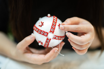Creative diy hobby. Making handmade craft white stylish Christmas balls with lace.