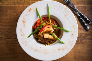 Chicken sauté. Sauteed Chicken Breast with Vegetables, garnished with scallion. Overhead, horizontal