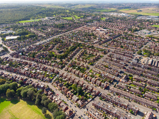 Aerial photo of the town known as Beeston in Leeds West Yorkshire UK, showing a rows of houses in a typical British housing estate taken with a drone on a bright sunny.