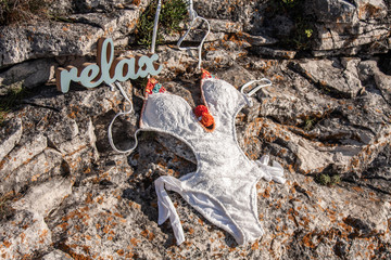 Wooden relax text and a swimsuit on a rock