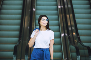Young adult beautiful brunette girl happy businesswoman on escalator in business center