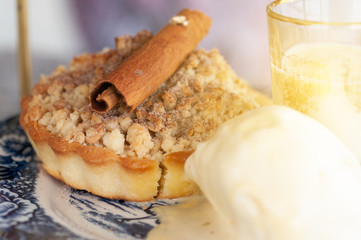 Apple crumble crispy pie with ice cream and topping with cinnamon stick.