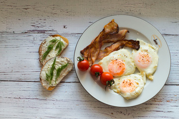 Sandwiches with curd cheese and fried eggs with bacon