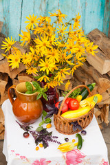 Bouquet of flowers and basket with autumn crop of seasonal vegetables