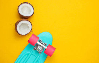 Creative summer concept. Skateboard, coconut halves on a yellow background. Copy space, top view © splitov27