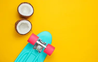 Rollo Creative summer concept. Skateboard, coconut halves on a yellow background. Copy space, top view © splitov27