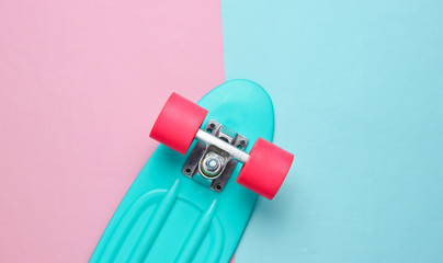 Trendy hipster skateboard on pink blue pastel background. Minimalism concept. Youth lifestyle. © splitov27