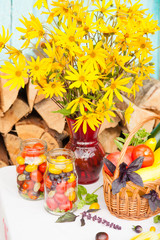 Bouquet of flowers and basket with autumn crop of seasonal vegetables
