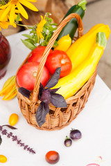 Bouquet of flowers and basket with autumn crop of seasonal vegetables