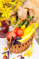 Bouquet of flowers and basket with autumn crop of seasonal vegetables
