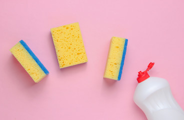 Set of housewives for washing dishes. Dishwasher. Bottle of washing utensils, sponges on pink background. Top view.