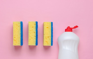 Set of housewives for washing dishes. Dishwasher. Bottle of washing utensils, sponges on pink background. Top view.