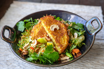 Organic veggie salad from broccoli, cashew , mild chilli and lime. Zesty and vibrant with galangal and kaffir lime. Topped with corn fritters and a rich paprika salsa on island Bali, Indonesia