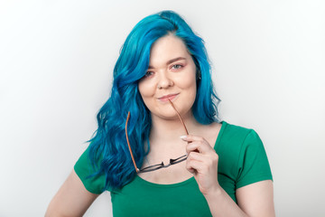 Youth, stylish and fashion concept - Young beautiful woman with blue hair and eyeglasses is smiling over white background